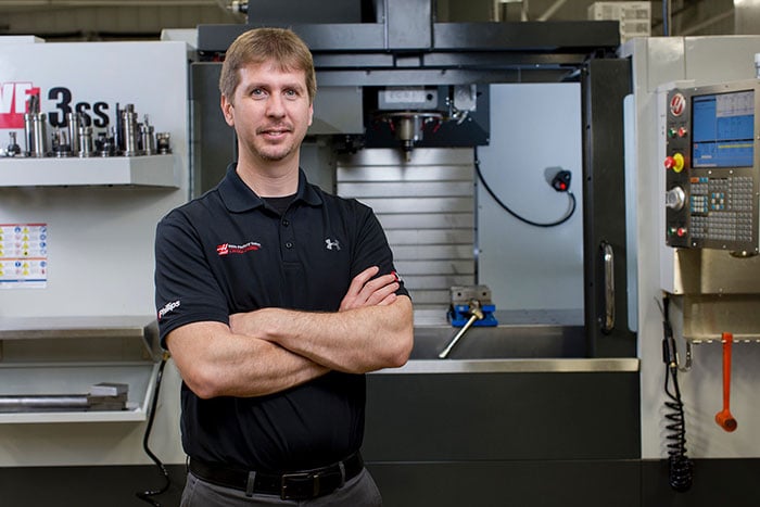 Ben VandeHoef standing in front of Haas machinery and equipment.